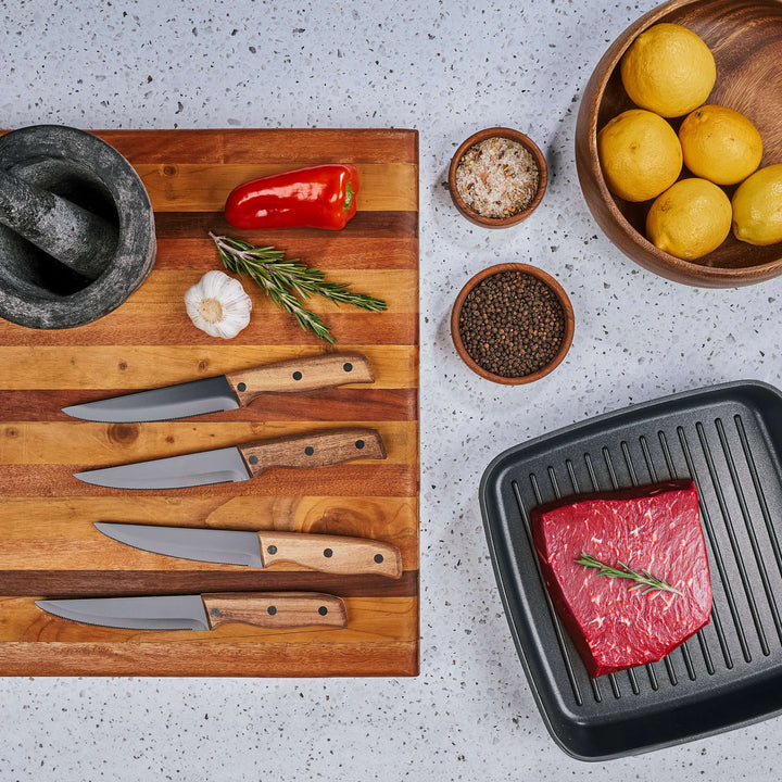 Andy Cartwright branded steak knives on wooden board