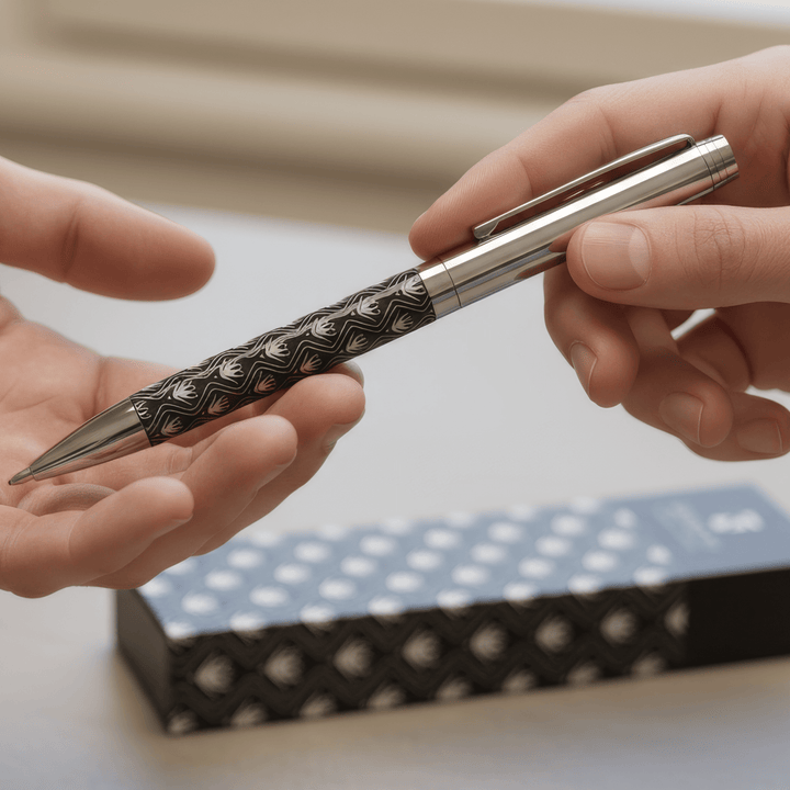 Sengetti Protea Heritage Ball Pen being handed over, showcasing its fine Protea pattern and chrome finish.